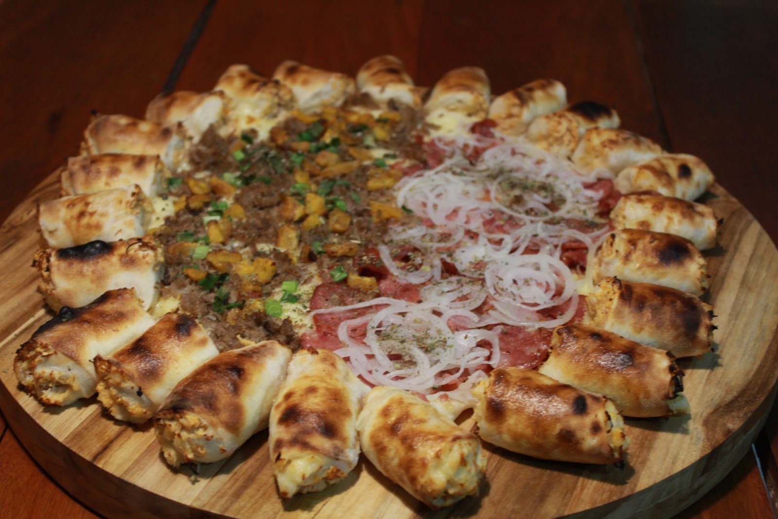 Pizza grande com borda recheada em toda a volta e cobertura de carnes e cebola